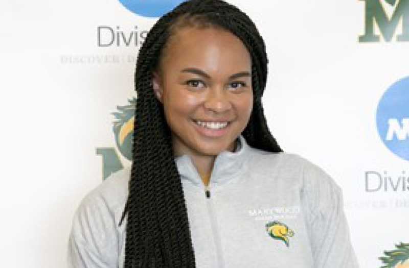 Young woman smiling in front of Marywood banner.